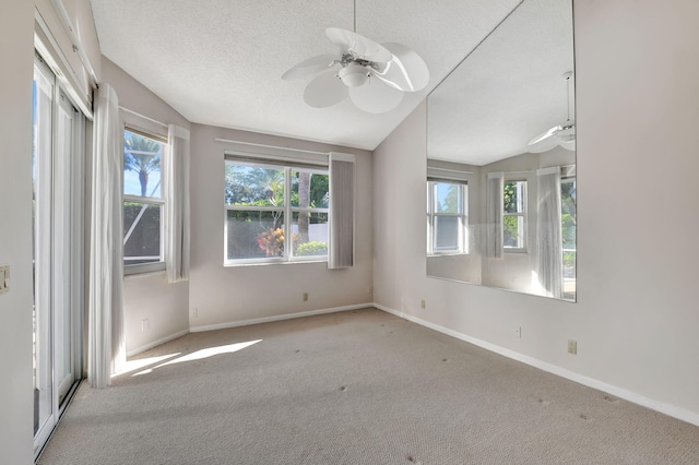 unfurnished room with a textured ceiling, ceiling fan, light colored carpet, and vaulted ceiling