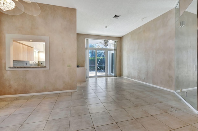 tiled spare room with a textured ceiling, ceiling fan, and sink