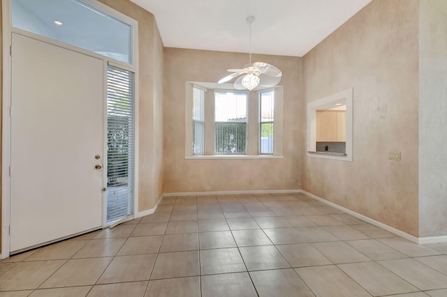 interior space with ceiling fan, a wealth of natural light, and light tile patterned flooring