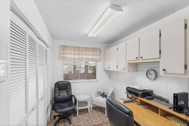 carpeted bedroom featuring ceiling fan and a textured ceiling