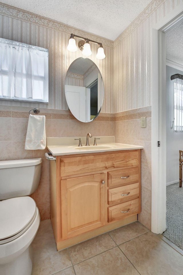 bathroom with vanity, a textured ceiling, tile patterned floors, and tile walls