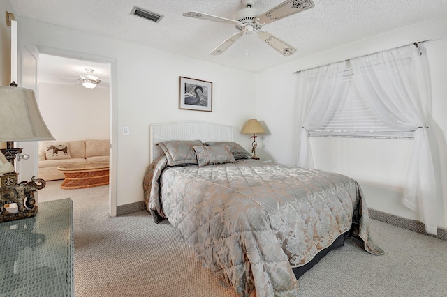 bedroom with carpet flooring, a textured ceiling, and ceiling fan