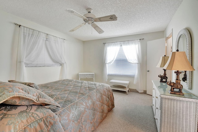 carpeted bedroom featuring a textured ceiling and ceiling fan