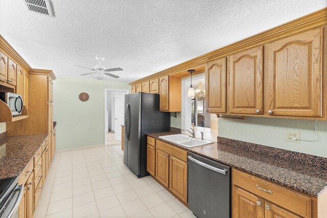 kitchen with ceiling fan, sink, pendant lighting, a textured ceiling, and appliances with stainless steel finishes