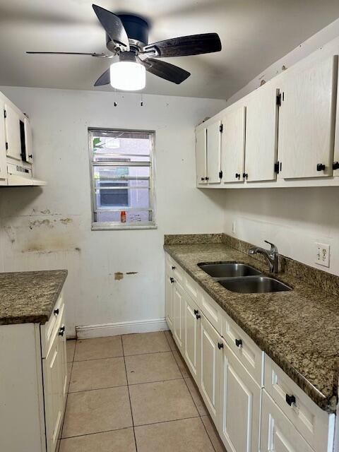 kitchen with white cabinets, ceiling fan, light tile patterned flooring, and sink