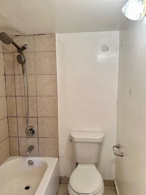 bathroom featuring tiled shower / bath and toilet