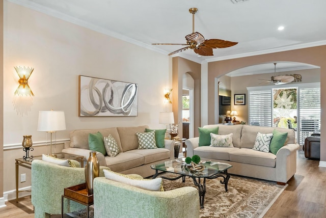 living room featuring a wealth of natural light, crown molding, and light hardwood / wood-style floors