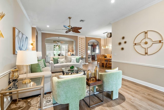 living room with crown molding, ceiling fan, and wood-type flooring