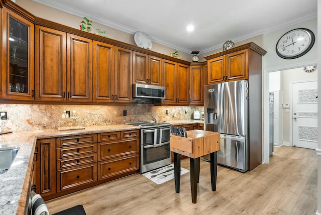 kitchen featuring backsplash, stainless steel appliances, light stone counters, and ornamental molding