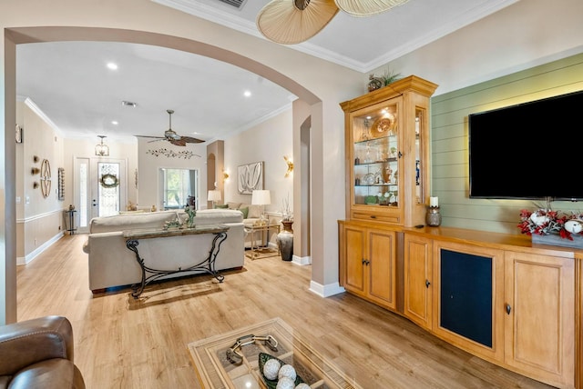 living room with light wood-type flooring, ceiling fan, and crown molding