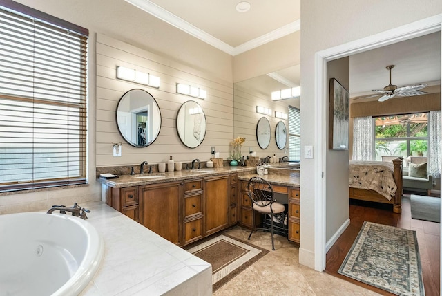 bathroom featuring ceiling fan, tile patterned floors, tiled bath, crown molding, and vanity