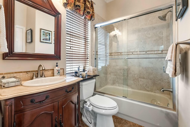 full bathroom featuring combined bath / shower with glass door, vanity, and toilet