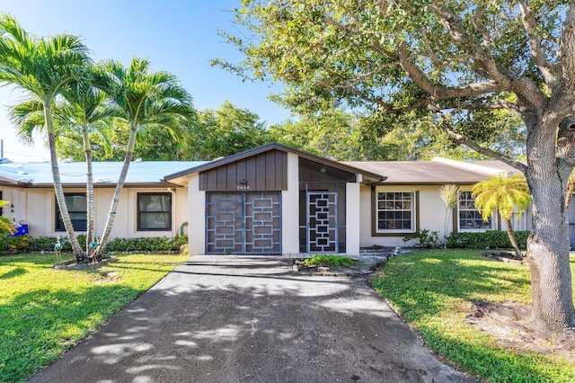 ranch-style home featuring a garage and a front lawn