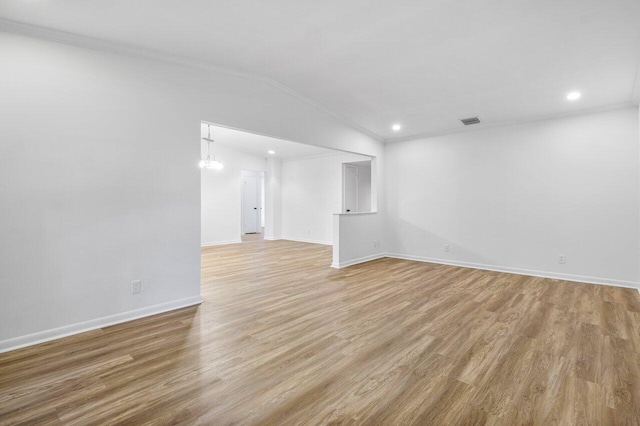 unfurnished living room with crown molding, light hardwood / wood-style flooring, and vaulted ceiling