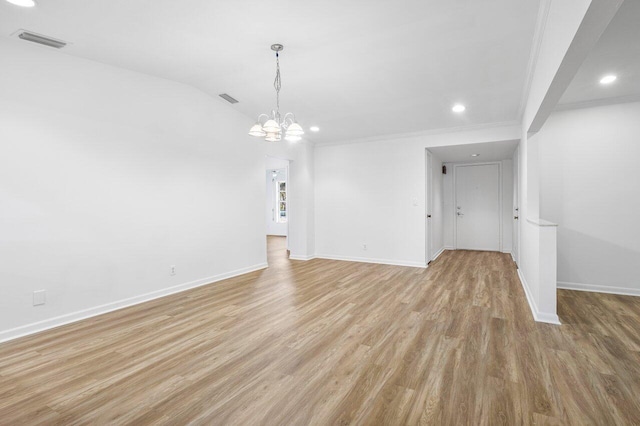 interior space with light hardwood / wood-style floors, crown molding, and a chandelier