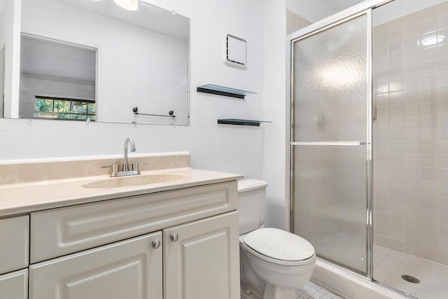 bathroom with tile patterned flooring, vanity, toilet, and a shower with shower door