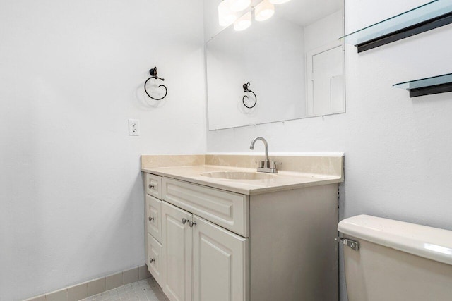 bathroom featuring tile patterned floors, vanity, and toilet