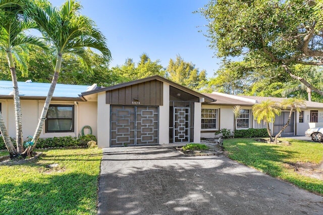 single story home featuring a garage and a front yard