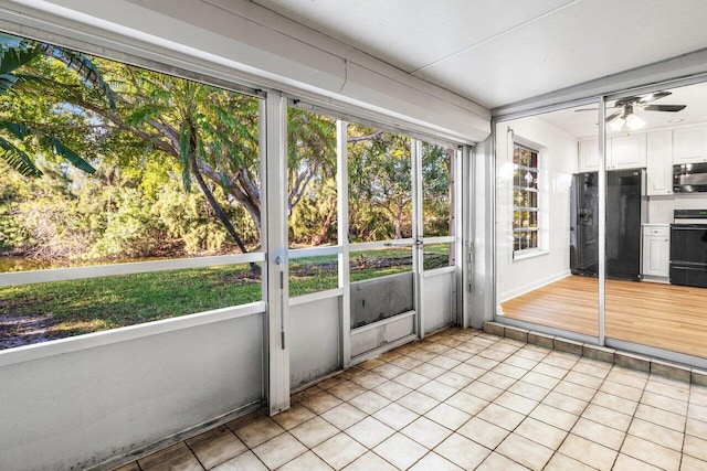 unfurnished sunroom featuring ceiling fan