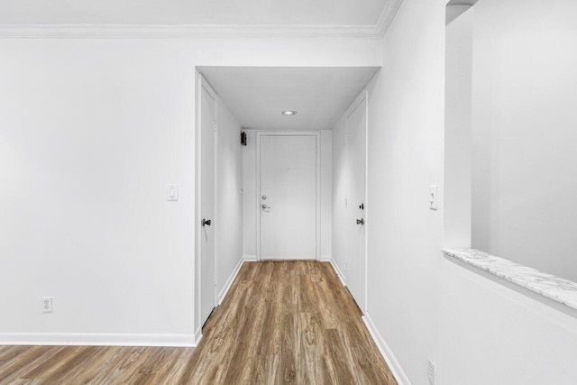 corridor featuring ornamental molding and hardwood / wood-style flooring