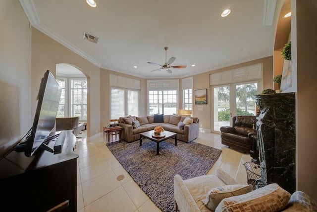 living room featuring ceiling fan, a healthy amount of sunlight, ornamental molding, and light tile patterned floors