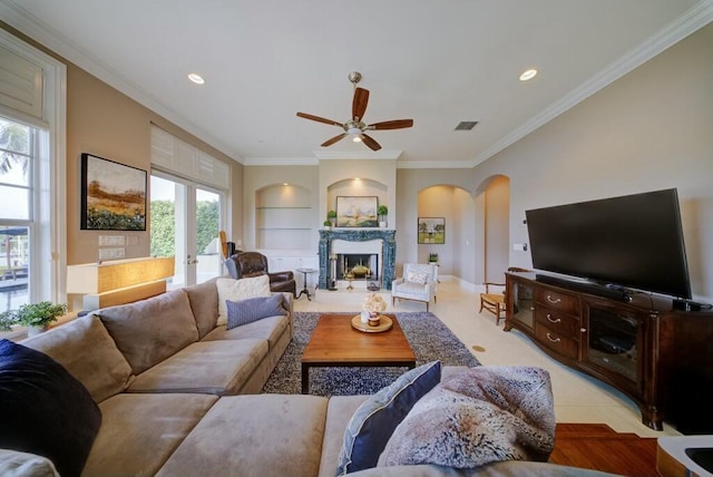 living room featuring crown molding, built in features, and ceiling fan