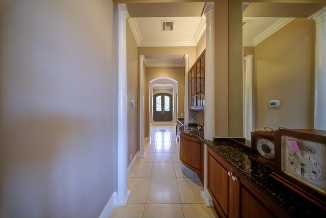 hallway with ornate columns, light tile patterned flooring, and crown molding