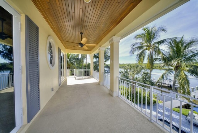 balcony featuring ceiling fan and a water view