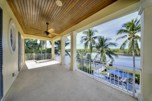 view of patio / terrace featuring a balcony, a water view, and ceiling fan