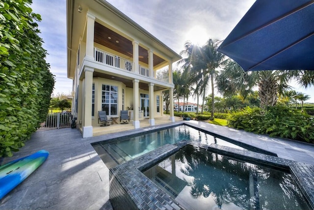 view of swimming pool featuring a patio and an in ground hot tub