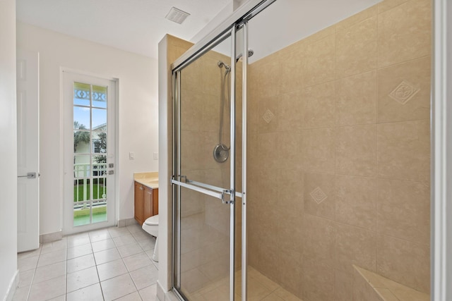 bathroom with tile patterned floors, vanity, toilet, and walk in shower