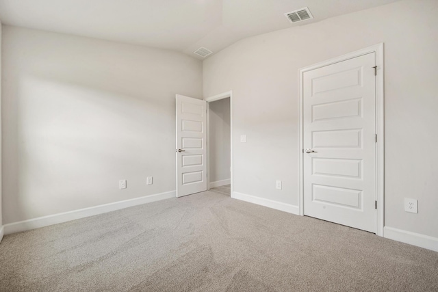 empty room with carpet flooring and lofted ceiling