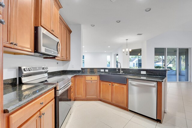 kitchen with an inviting chandelier, sink, light tile patterned flooring, kitchen peninsula, and stainless steel appliances