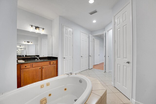 bathroom with vanity, tile patterned floors, and tiled tub