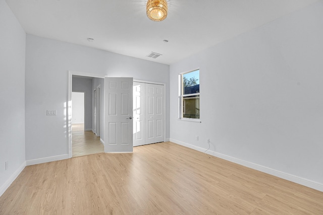 unfurnished bedroom featuring light hardwood / wood-style floors and a closet