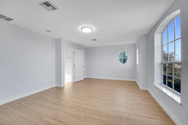 spare room with a healthy amount of sunlight and light hardwood / wood-style flooring