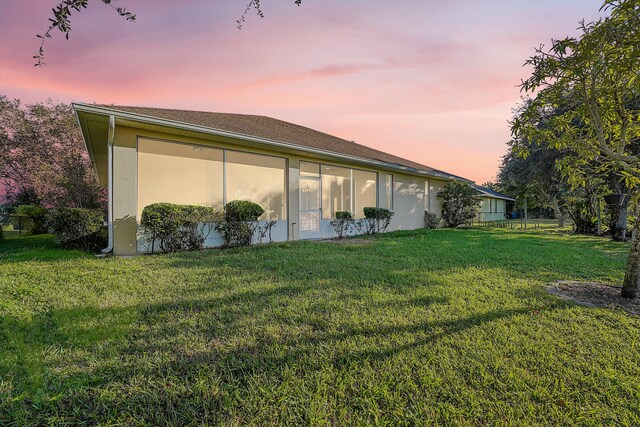 back house at dusk with a yard