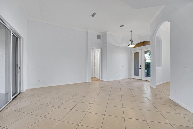 spare room with ornamental molding, light tile patterned floors, and french doors