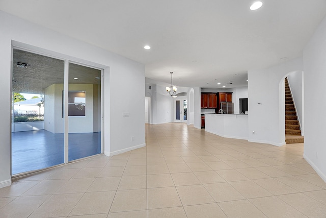 unfurnished living room featuring light tile patterned floors and a chandelier