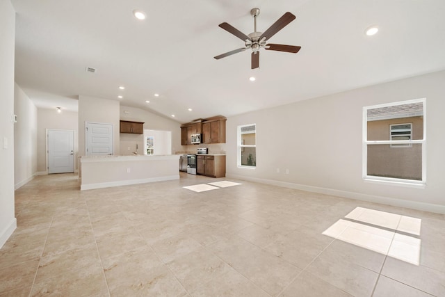 unfurnished living room with ceiling fan, sink, light tile patterned floors, and lofted ceiling