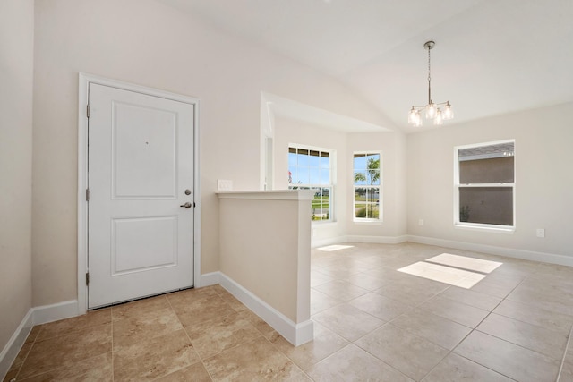 entryway with vaulted ceiling, a notable chandelier, and light tile patterned flooring