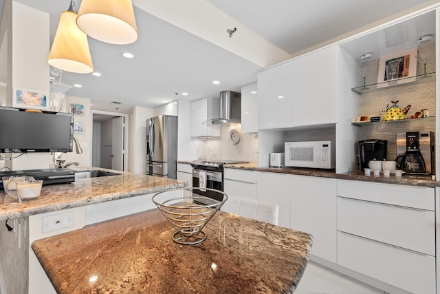 kitchen featuring white cabinets, tasteful backsplash, modern cabinets, wall chimney range hood, and appliances with stainless steel finishes