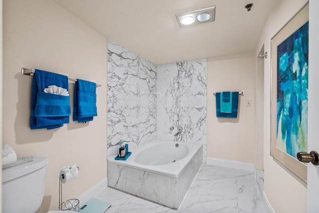 bathroom with marble finish floor, baseboards, toilet, and a garden tub