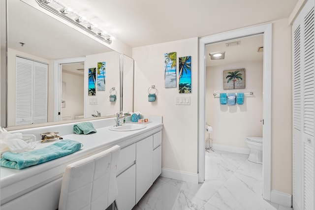 bathroom with baseboards, toilet, and a closet