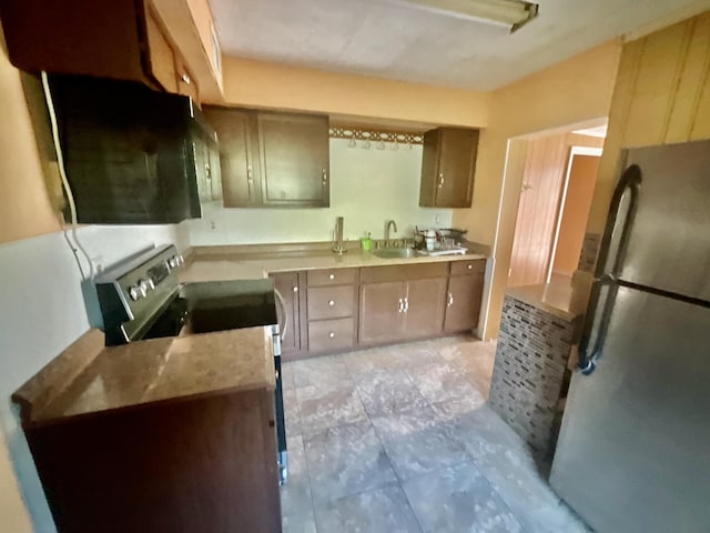 kitchen with kitchen peninsula, stainless steel fridge, sink, and electric stove