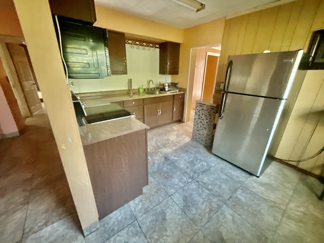 kitchen featuring stainless steel fridge, range, and sink