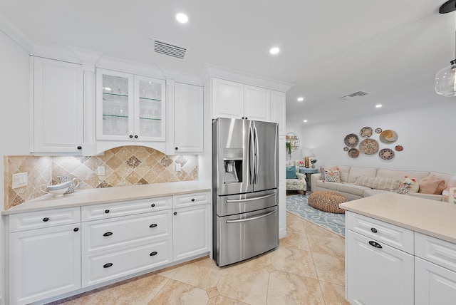 kitchen featuring white cabinets, backsplash, and stainless steel refrigerator with ice dispenser