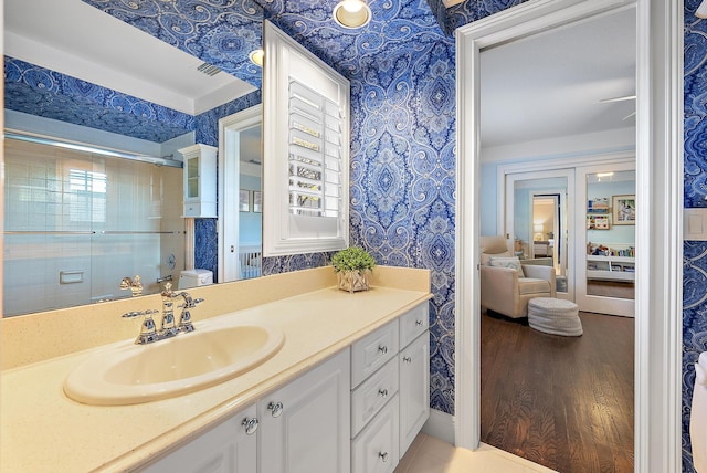 bathroom featuring vanity, toilet, plenty of natural light, and a shower with shower door