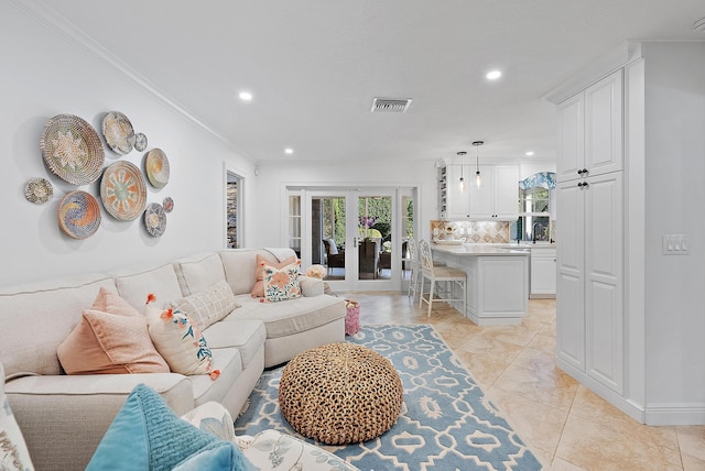 tiled living room featuring ornamental molding, sink, and french doors