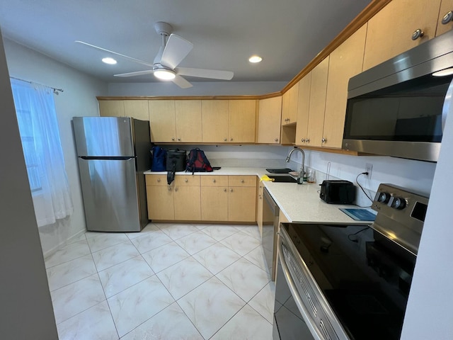 kitchen featuring sink, light brown cabinetry, ceiling fan, and appliances with stainless steel finishes